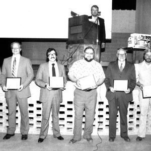 00-00-0000 Annual Meeting John Scherer at Podium _ _ Garland Gates-J Adams-K Adams-S Schroder-B Neice-website