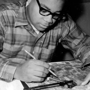 00-00-0000 Man sitting at table writing on chart. Photo by Robert Mills