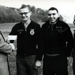 Land Judging unidentified man giving award to 3 young people #2-Website