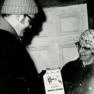 Making Maple Syrup-Man and Woman Examine Container of Syrup (photo by Robert Mills)