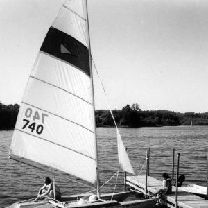 Man in sailboat, man on dock.Photo by Robert Mills