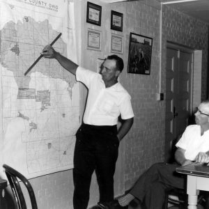 Man pointing to watershed map as two look on .Photo by Robert Mills
