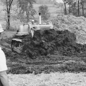 Man pushing dirt while another looks on .Photo by Robert Mills