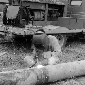 Man welding two pipes together .Photo by Robert Mills