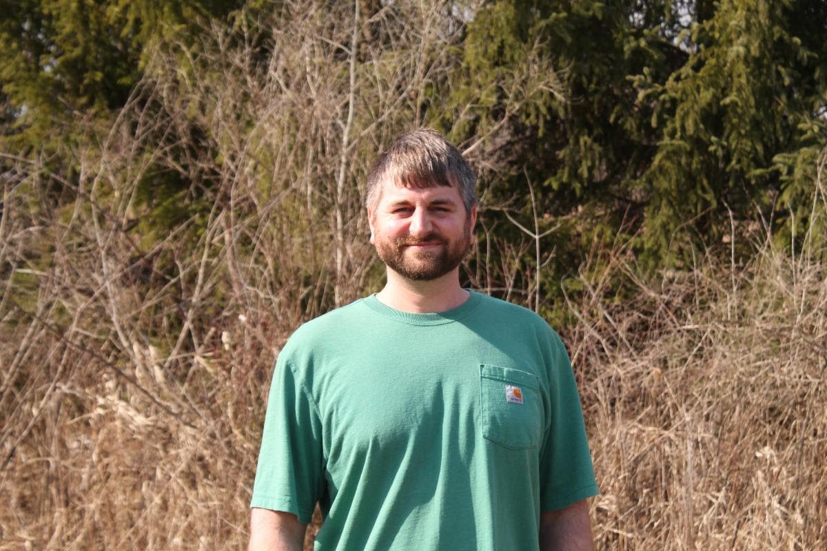 Sam standing outdoors posed and smiling