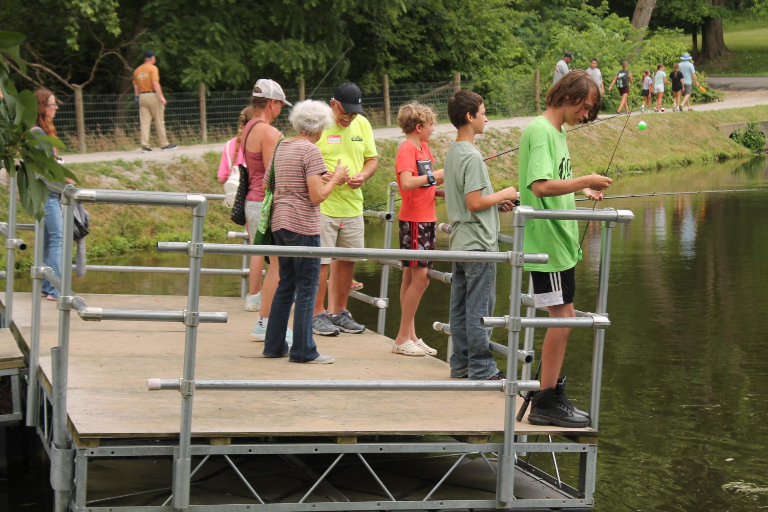 Families gathered on a dock fishing 