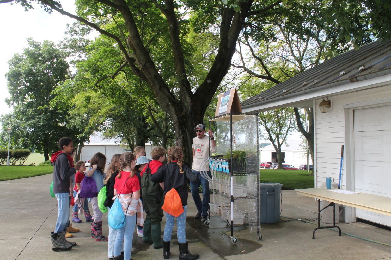 Technician Jordan with the rainfall simulator and a group of kids