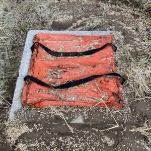 Two types of inlet protection. The top photo shows a catch basin wrapped in silt fence, The bottom photo has the grate of a catch basin wrapped in a bag to catch sediment.