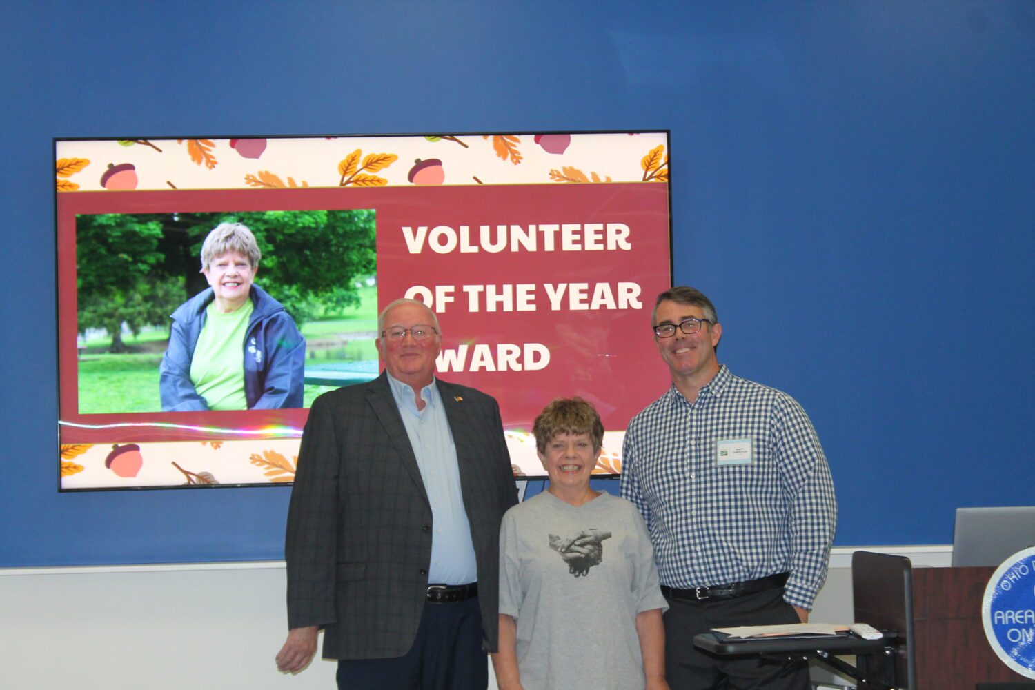 Elaine posed with Commissioner Banks and Director Matt Christian. They're all smiling for the camera.