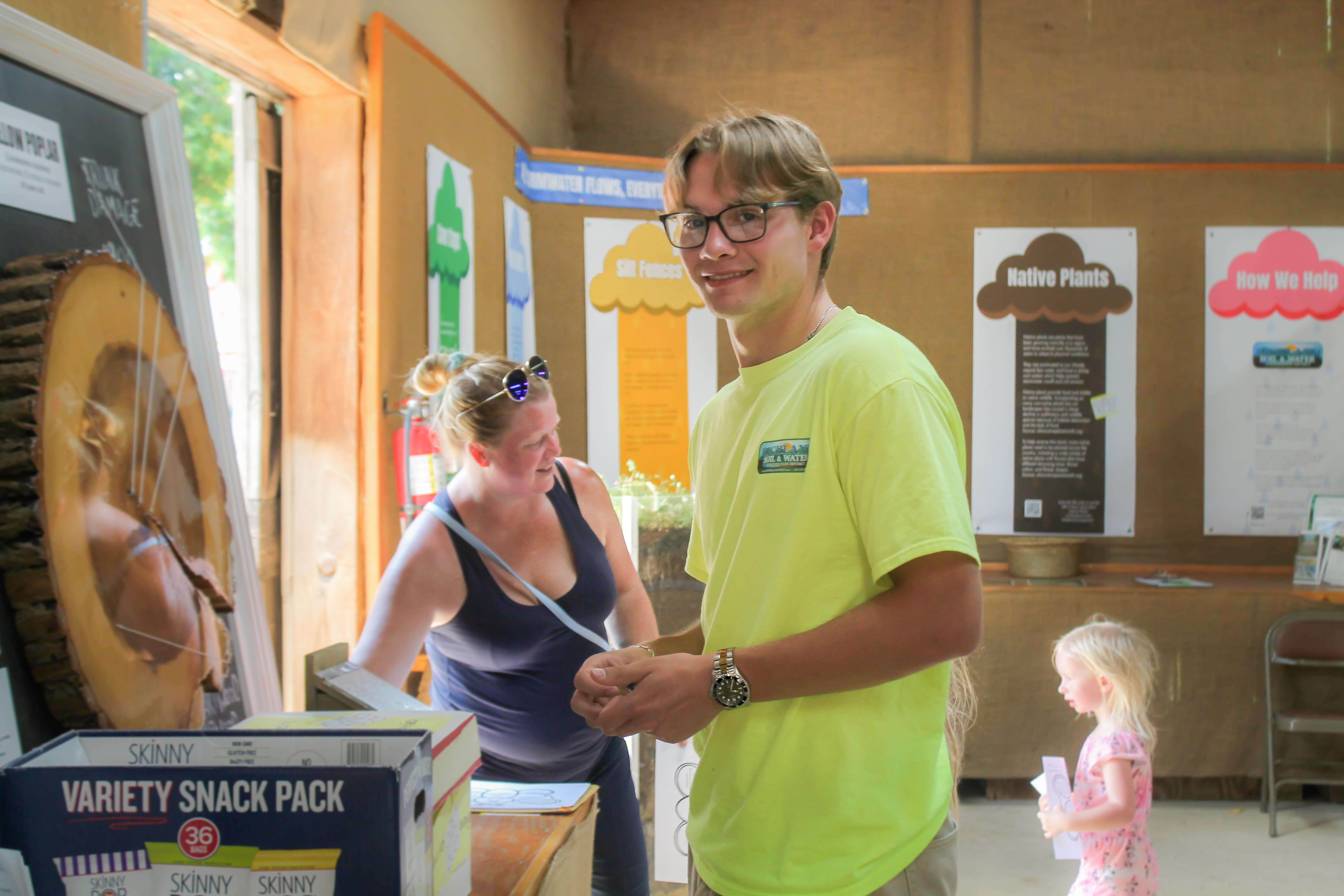 Daniel standing in front of the fair display smiling at the camera.
