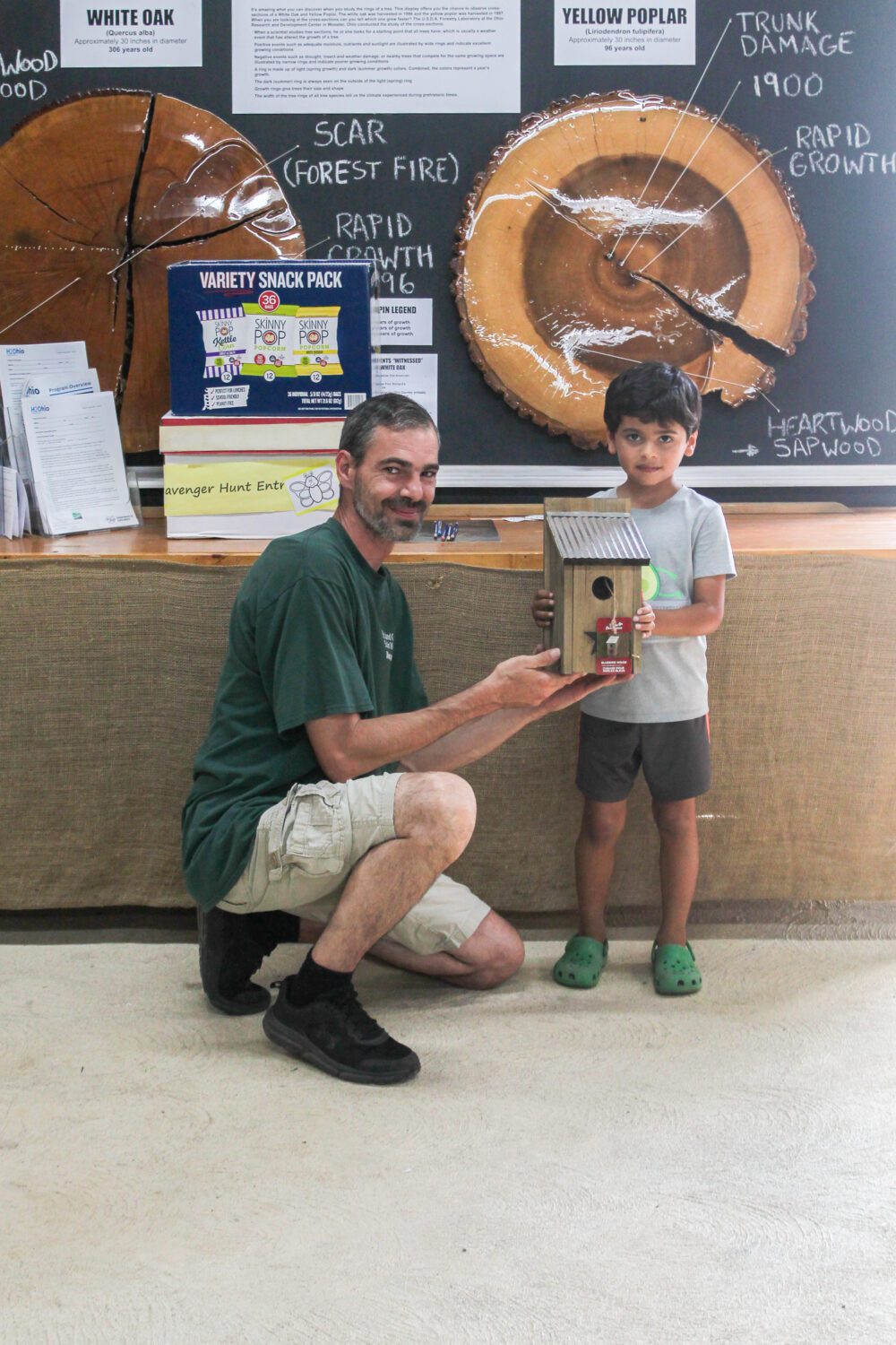 Pete from Richland County Solid Waste posing with one of the young winners. They're holding up the prize birdhouse and smiling.