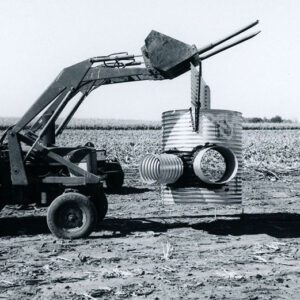 Tractor with a Fork Lifting a Corrugated Drainage Pipe