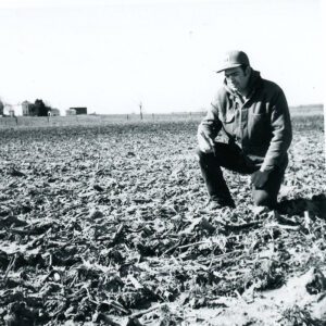March 22, 1976, Ron VanAnsdale examines a chisel plowed field.