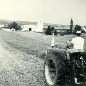 May 24, 1961 Man on tractor in a field of stubble.