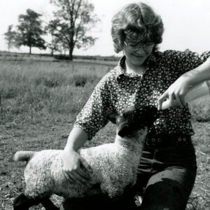 June 3, 1973 Leesa Rader, daughter of Mr. and Mrs. Delvin Rader, bottle feeds a lamb at the family farm