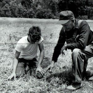 June 12, 1972 Gary Forbes, grandson, with Clarence Forbes. They examine the frost damaged No-till farm.