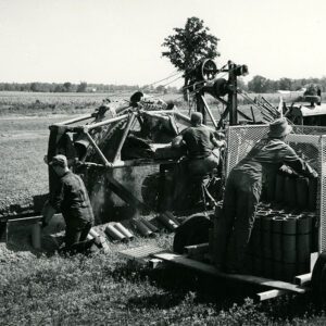 August 3, 1965 Ed Cook Farm. Ed in Trench. Ronald Cooke, Son of Maurice, Fred Cooke on Slied, Ed Susan Cooke on Tractor. New Chariot Tube Trailer. Palletized Tile.